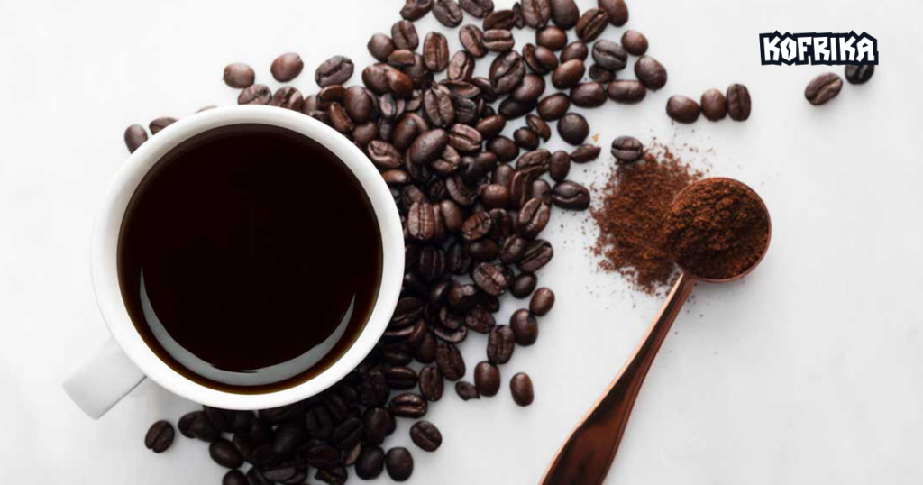 
Alt-text: Top view of a coffee cup, brown coffee beans scattered around, brown spoon with brown coffee powder
